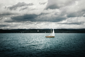 Ein Segelschiff bei rauer See mit bewölktem Himmel.
